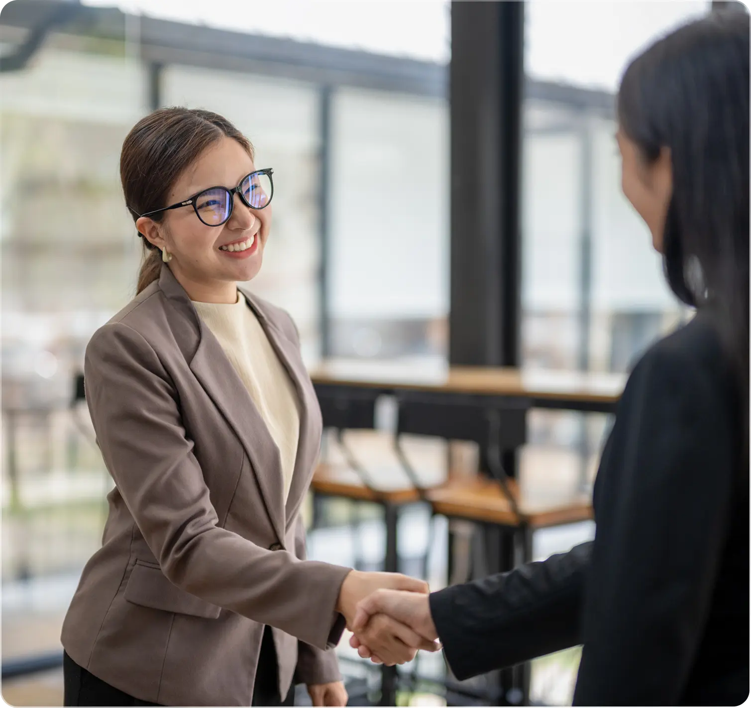 Two people shaking hands in an office.