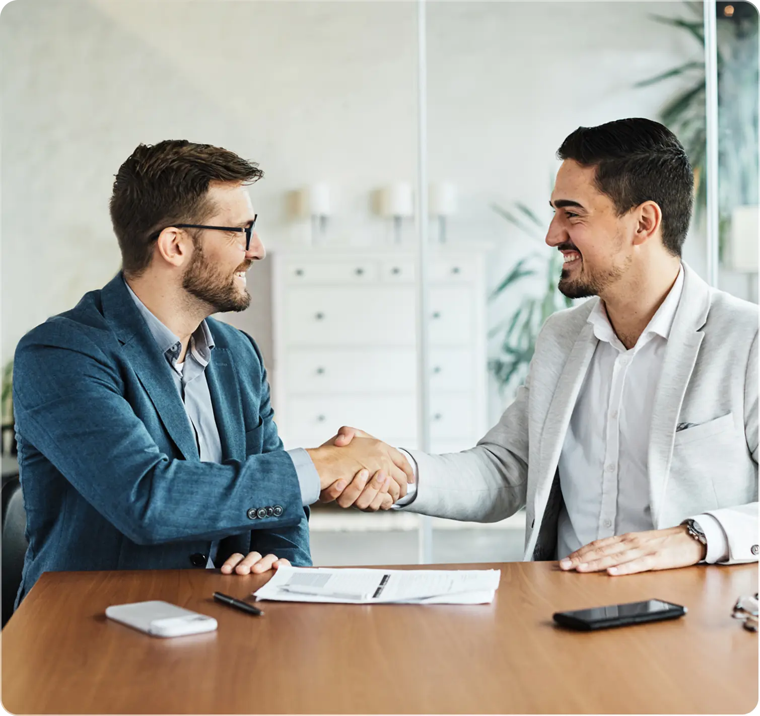 Two businessmen shaking hands in office.
