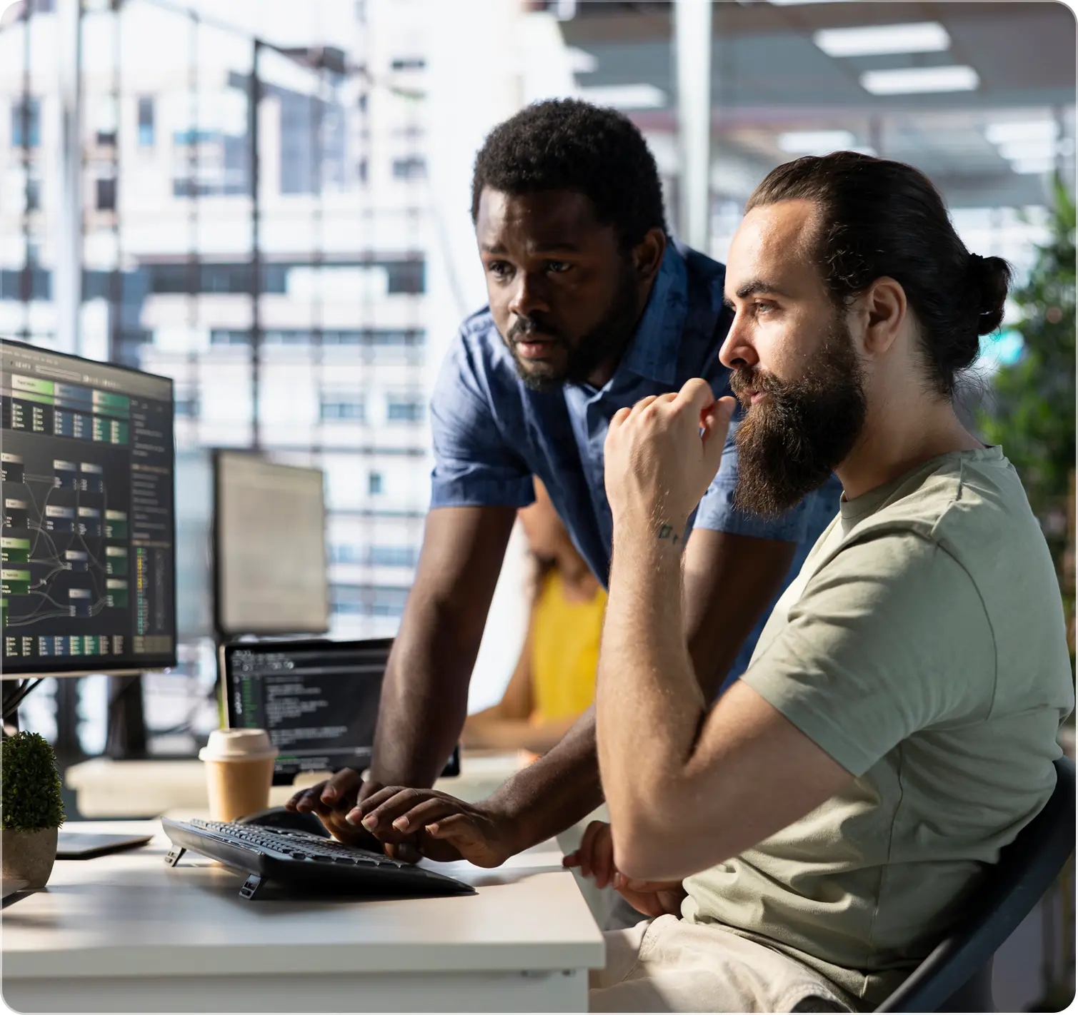 Two men collaborating at computer workstation.